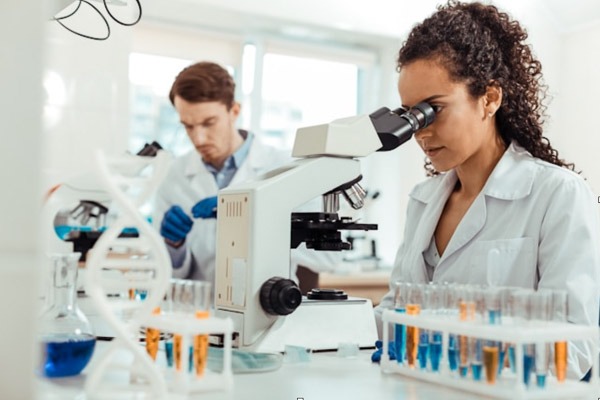 Scientists analysing peptide samples under a microscope